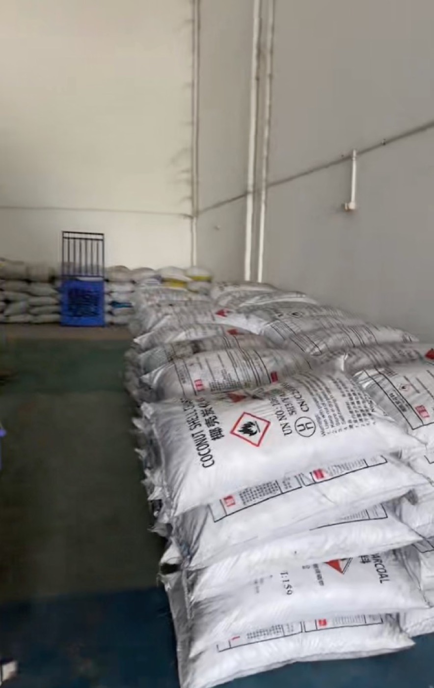 Bagged coconut shell charcoal inventory inside a Jakarta warehouse